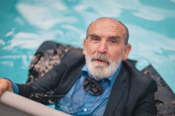 Gaetano Orazio in giacca e papillon, immerso nell’acqua turchese.