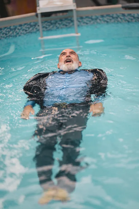 Gaetano galleggia supino nell’acqua, ancora vestito.