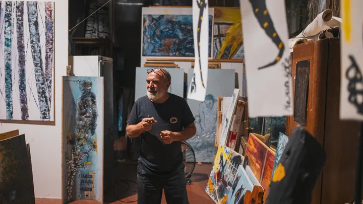 Gaetano circondato dai dipinti nel suo atelier.