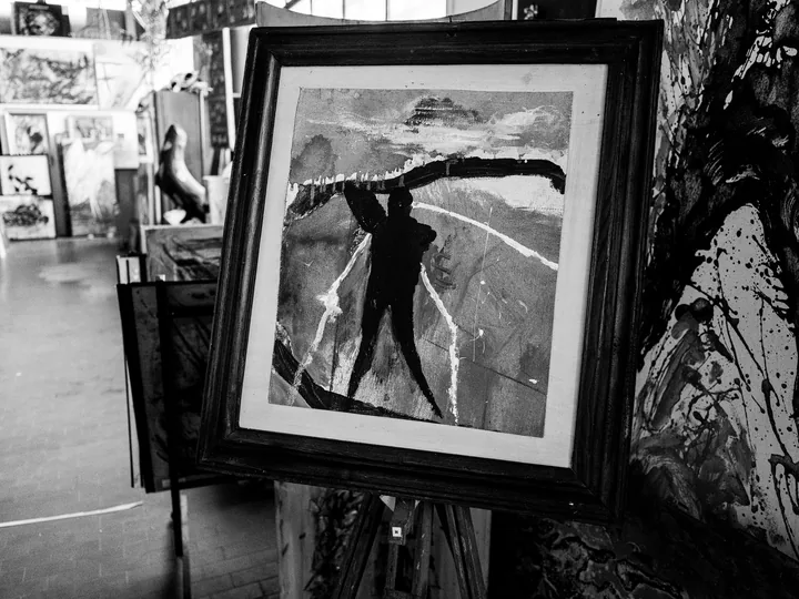 Un dipinto con una figura scura appoggiato nell’atelier.