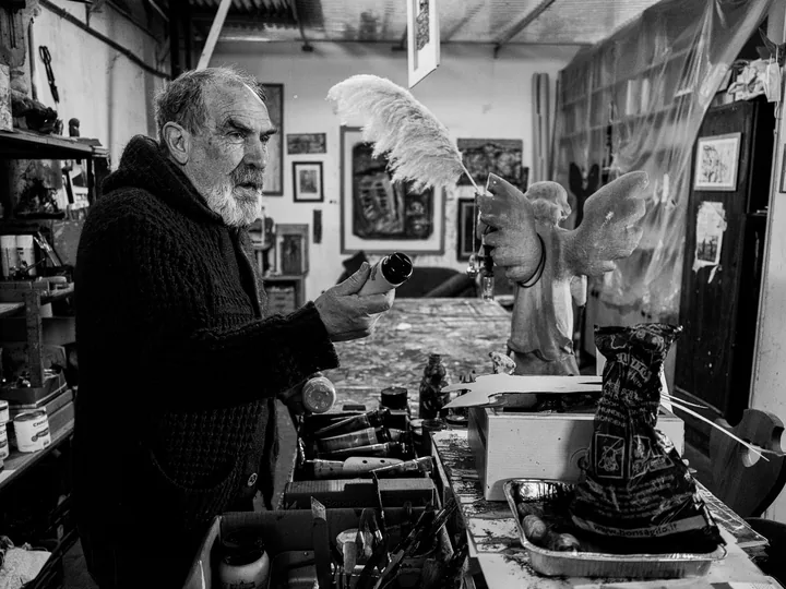 Gaetano parla accanto alla stufa nell’atelier.