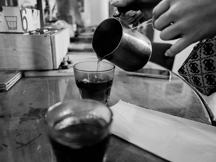 Il caffè viene versato dalla moka in un bicchiere.