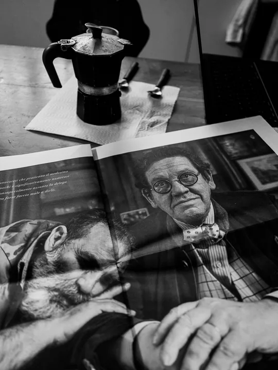 Una moka e un libro aperto su un ritratto fotografico.